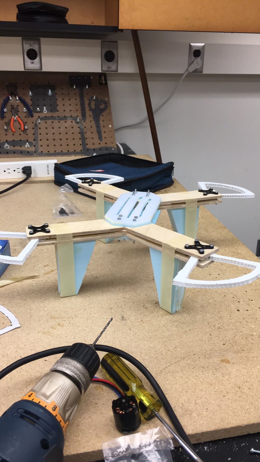 Frame assembly — wood cross, foam landing pads, motor mounts
